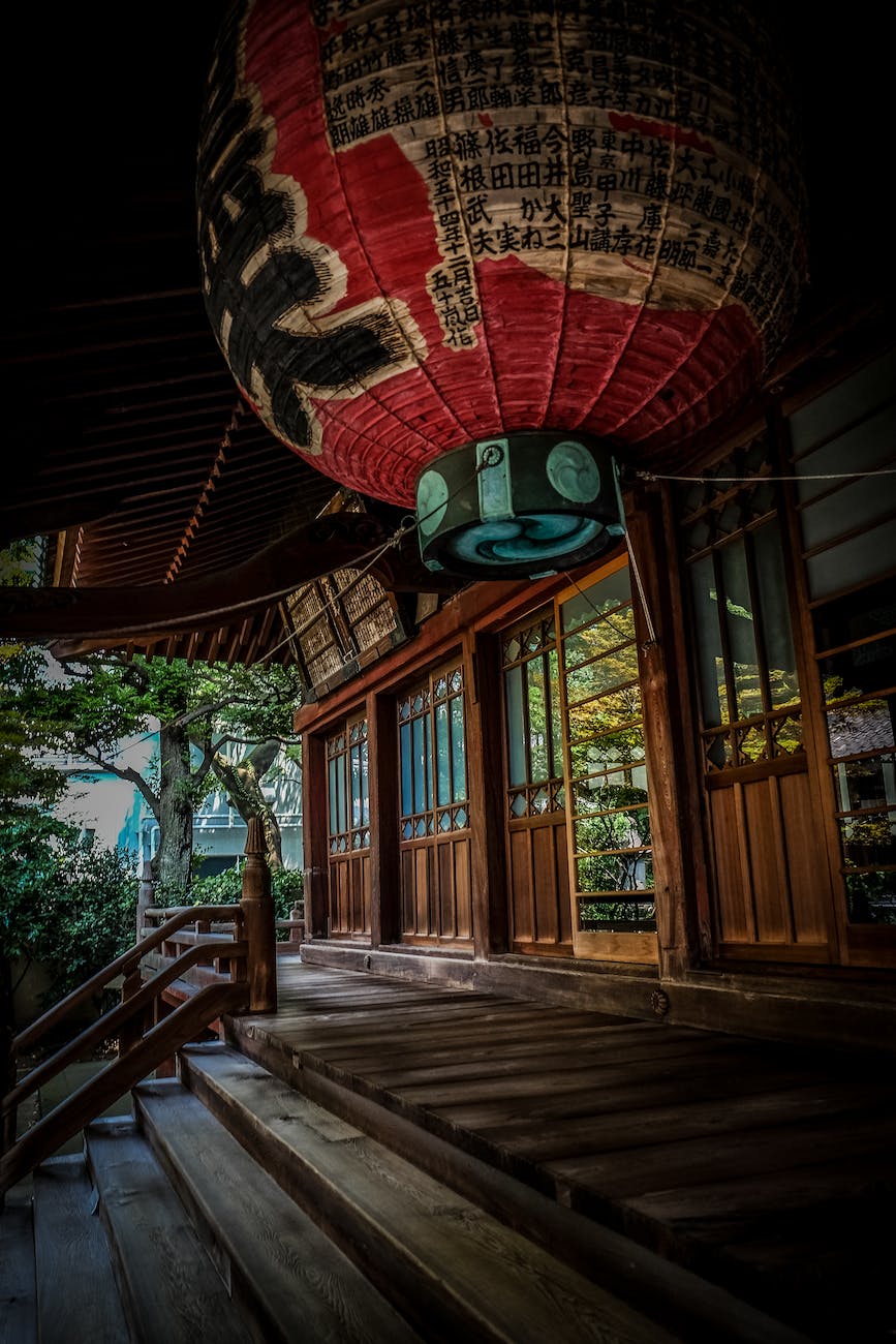 red green and black floating lantern with kanji text decoration above stairs