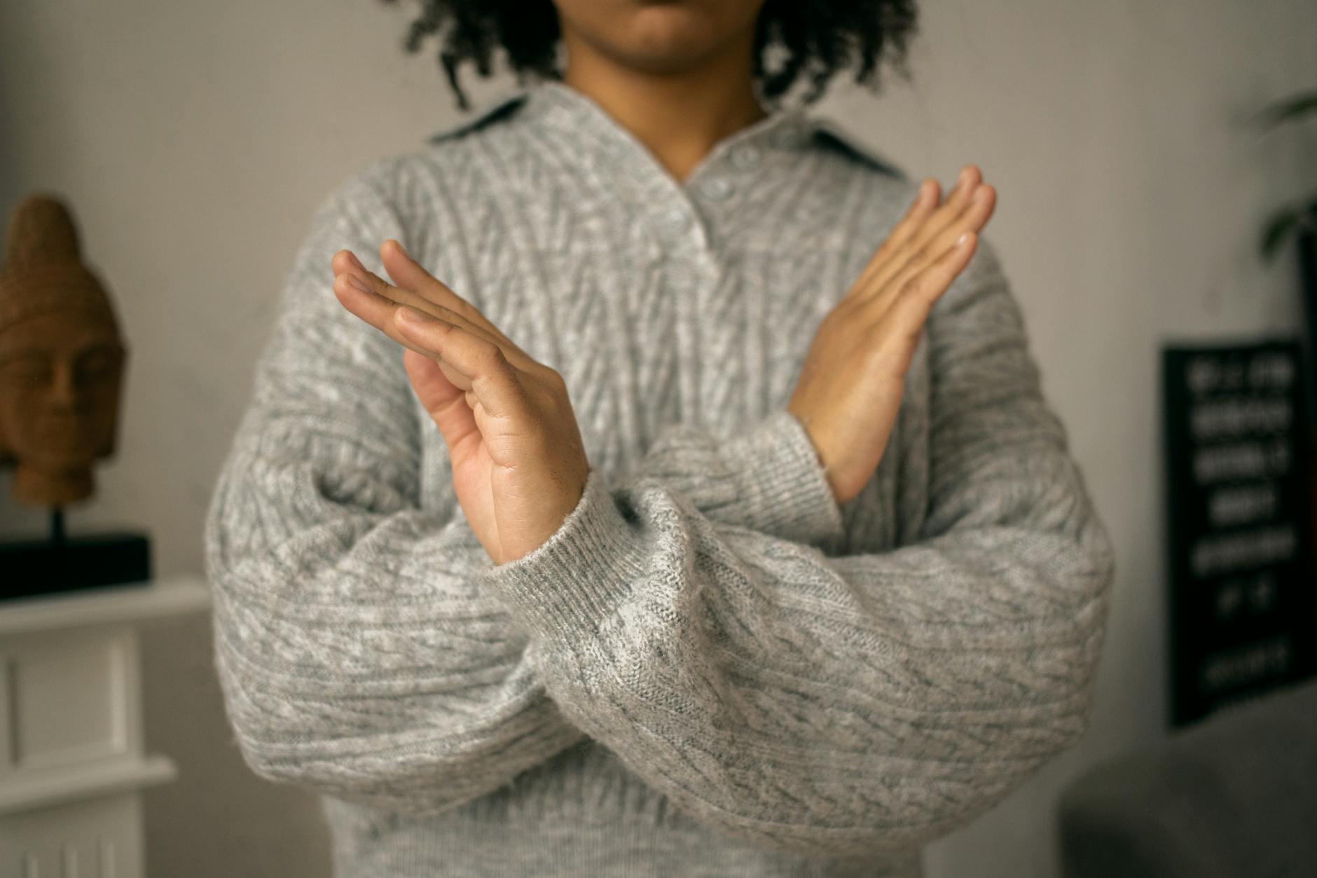 calm black woman crossed arms as restriction sign in light room